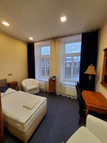 Hotel Koruna penzion في تبليتسه ناد ميتوجي: غرفة فندقية بسريرين ومكتب ونوافذ