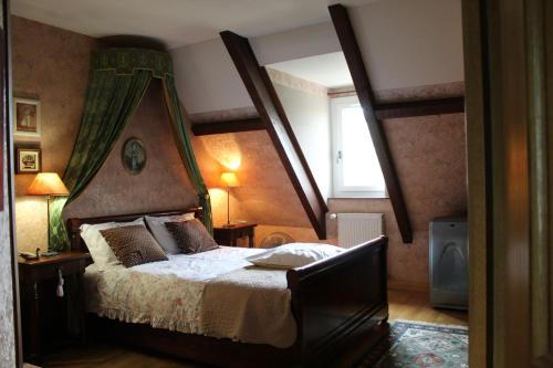 une chambre avec un grand lit à baldaquin dans l'établissement La Renaudiere en bourgogne, à Gergy