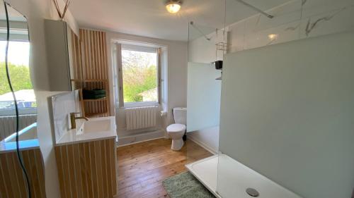 a bathroom with a sink and a toilet and a window at Le Clos des Marais in Champagné-les-Marais