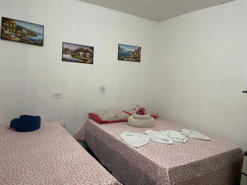 - une chambre avec 2 lits avec des draps roses dans l'établissement Cantinho da mery 1, à Maragogi