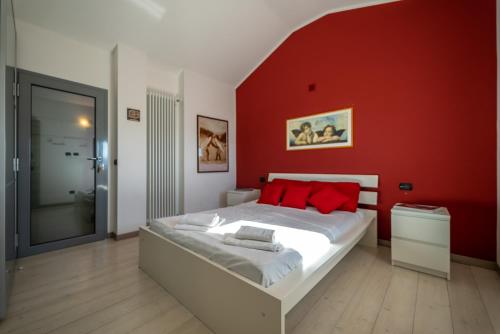 a bedroom with a bed with a red wall at Chalet la Cà del Fermo in Perledo