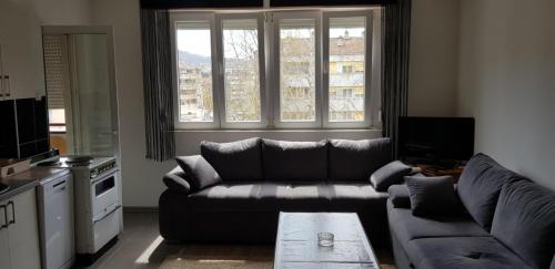 a living room with a couch and a large window at STAN 54m2 in Priboj