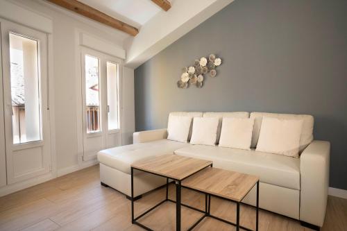 a living room with a white couch and a table at Apartamentos Terraza Ega in Estella