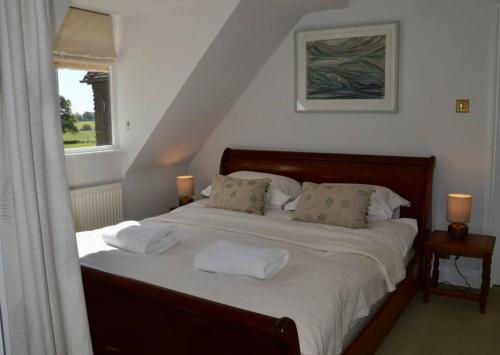 a bedroom with a bed with two pillows and a window at The Annex, Westerlands, Graffham in Graffham