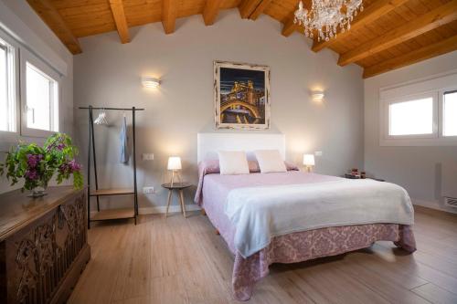 - une chambre avec un grand lit et un lustre dans l'établissement Apartamentos Terraza Ega, à Estella