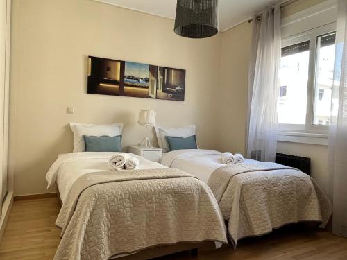 sypialnia z 2 łóżkami i kocami w obiekcie Stunning Penthouse Combo near Glyfada - free Parking w Atenach