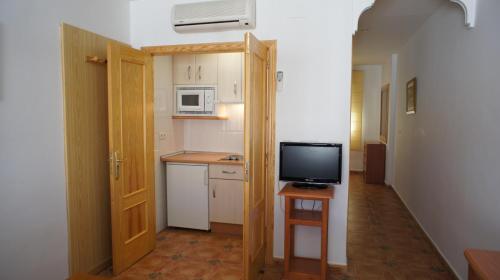 una piccola cucina con un televisore su un tavolo di Hotel Apartamentos Kantara Al-Saif ad Alcántara
