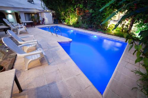 a large swimming pool with two chairs and a table at Posada de Rosas in Mendoza