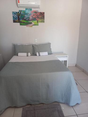 a bedroom with a bed with a gray comforter at HELLO MT POUSADA in Nobres
