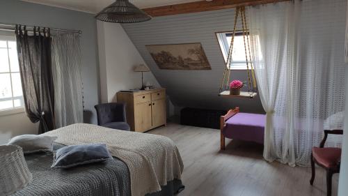 ein Schlafzimmer mit einem Bett, einem Stuhl und einem Fenster in der Unterkunft AUX 2 LACS chambres d'hôtes in Pierre-Percée
