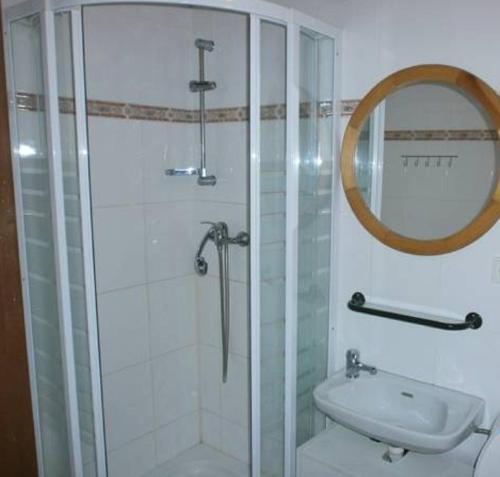 a bathroom with a shower and a sink and a mirror at Horská chata Roubenka in Strážné