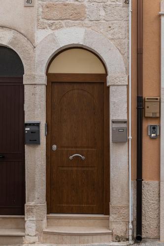 a wooden door in an archway in a building at Peter & Dove's House in Mola di Bari