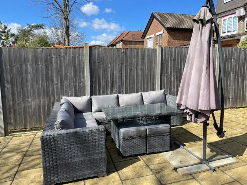 a patio with a couch and a table and an umbrella at Amazing Studio Apartment in North East London in London
