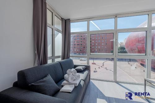 a living room with a blue couch and a large window at L'Archipel - Wifi - City centre in Perpignan