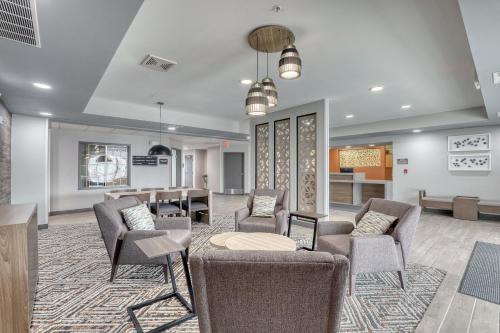 a waiting room with chairs and a table at Candlewood Suites Milwaukee Airport - Oak Creek by IHG in Greendale
