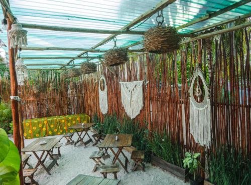 a covered patio with tables and chairs and plants at Arte Sano Hotel Only Adults - Near Beach in Holbox Island