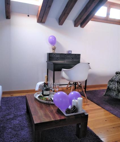 a room with a table with purple balloons and a piano at La Casona de Castilnovo - Gay Men Only in Valdesaz