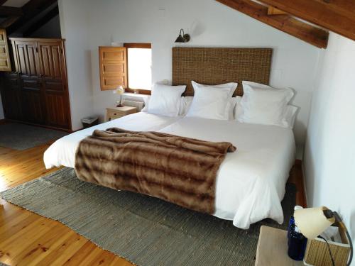 a bedroom with a large bed with a blanket on it at La Casona de Castilnovo - Gay Men Only in Valdesaz