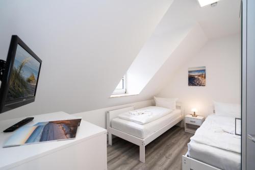 a white living room with a white couch and a window at Albatros OG in Tinnum
