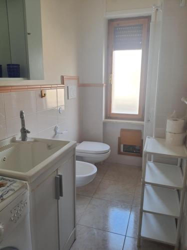 a white bathroom with a toilet and a sink at POLA 4 in Ginosa Marina