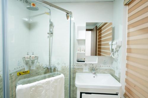 a bathroom with a sink and a glass shower at Thành Đô Hotel Hạ Long in Ha Long