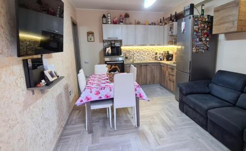 a kitchen and dining room with a table and a couch at Casa Laura, Quartu Sant'Elena in Su Forti