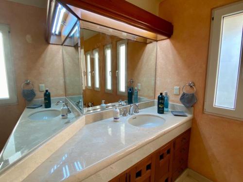 a bathroom with two sinks and a large mirror at Villa Navarro: Marina Vallarta in Puerto Vallarta