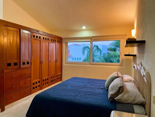 a bedroom with a blue bed and a window at Villa Navarro: Marina Vallarta in Puerto Vallarta