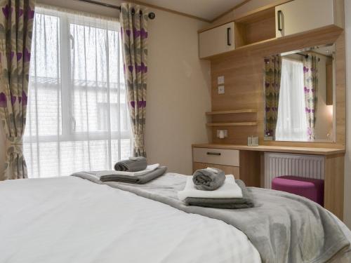 Brigham的住宿－Graylings Rest - Uk35759，一间卧室配有两张床、一张桌子和一面镜子