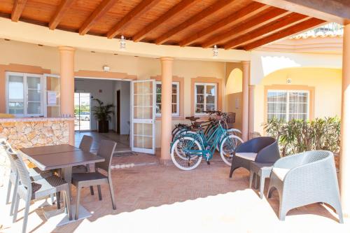 a patio with a table and chairs and bikes at Atalaia Sol Aparthotel - tennis & heated pool in winter in Lagos