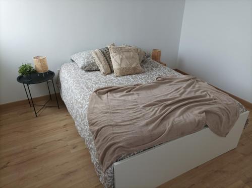 een bed in een slaapkamer met een witte muur bij Sweet Home in Mulhouse