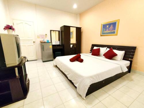 1 dormitorio con 1 cama y TV. en Jaroonwej Bangsaen, en Bang Saen