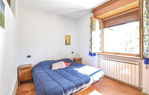 Ponte CaffaroにあるNice Apartment In Bagolino With Kitchenの青いベッドと窓付きの小さなベッドルームが備わります。