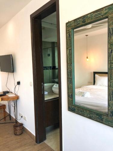 a mirror hanging on a wall next to a bedroom at Avatar Living@ Greater Kailash 2 in New Delhi