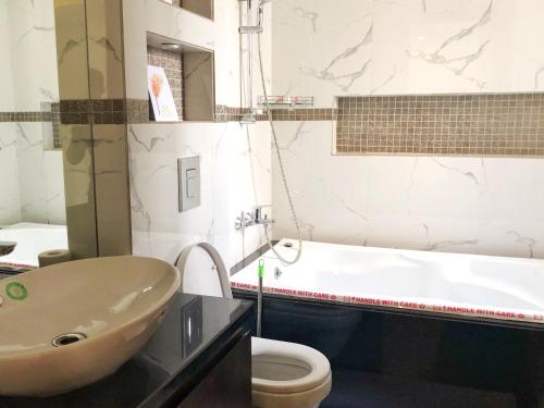 ein Badezimmer mit einem Waschbecken, einem WC und einer Badewanne in der Unterkunft Avatar Living@ Greater Kailash 2 in Neu-Delhi
