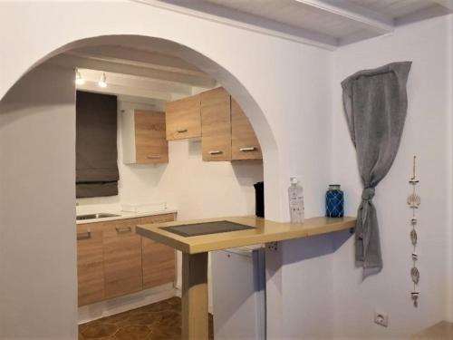 una cocina con encimera y un arco en una habitación en Windmill House Mykonos en Megali Ammos