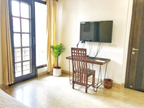 a room with a desk with a computer and a television at Avatar Living@ Greater Kailash 2 in New Delhi