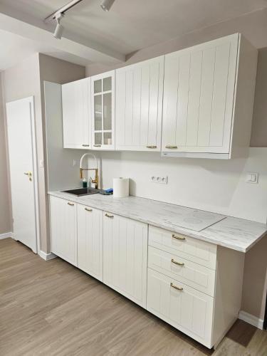 a kitchen with white cabinets and a counter top at MISVEST Tomasz Klimatyzacja in Zabrze