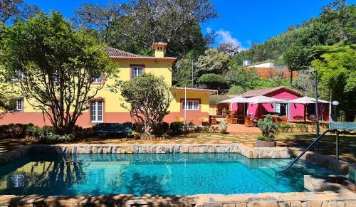 a house with a swimming pool in front of it at Quinta da Moscadinha in Camacha