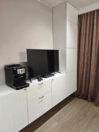 a television on a white cabinet in a room at MISVEST Tomasz Klimatyzacja in Zabrze