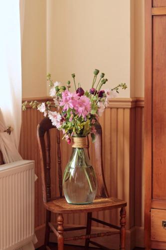 a vase filled with flowers sitting on a chair at Hotel Boutique Casa Werner in Puerto Varas