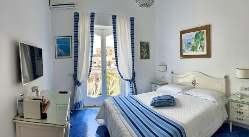 a bedroom with a bed and a window at Hotel Villa Delle Palme in Positano in Positano