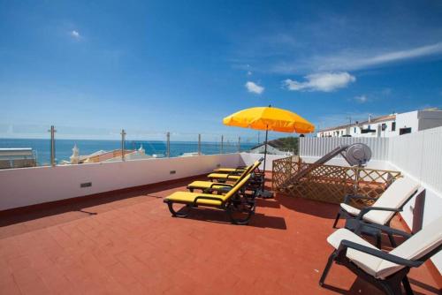 a group of lounge chairs and an umbrella on a roof at Casa Barros by GalanteVasques in Carvoeiro