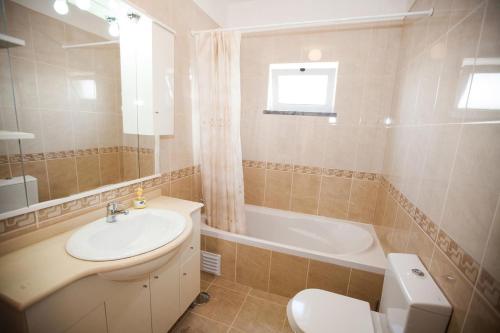 La salle de bains est pourvue d'un lavabo, de toilettes et d'une baignoire. dans l'établissement Casa Barros by GalanteVasques, à Carvoeiro