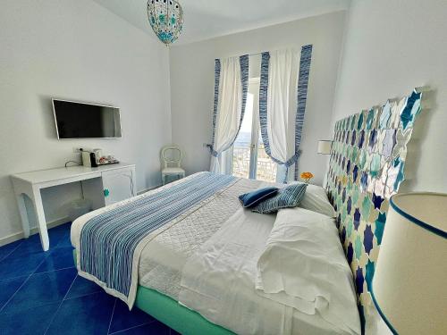 a bedroom with a bed and a television in it at Hotel Villa Delle Palme in Positano in Positano