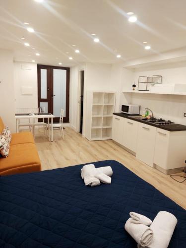 ein Wohnzimmer mit einem blauen Bett und eine Küche in der Unterkunft Il Munazzeno Centro Storico Amalfi in Amalfi