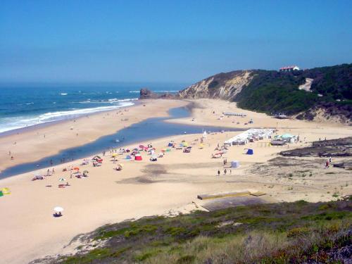 a group of people on a beach near the ocean at Linda House in Casais de São Mamede