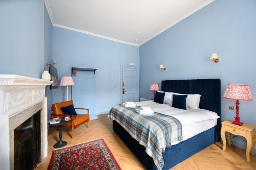 a blue bedroom with a bed and a fireplace at Cosy City Centre First Floor Family Room in Edinburgh