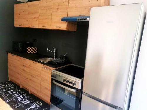 una cucina con frigorifero in acciaio inossidabile e lavandino di Linda House a Casais de São Mamede