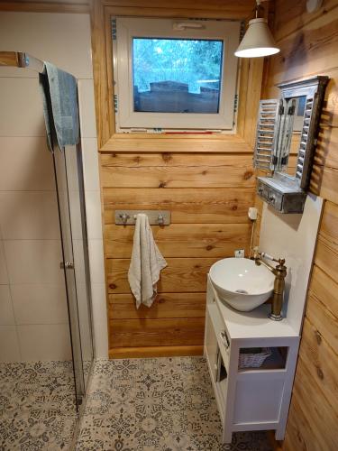 ein Bad mit einem Waschbecken und einem TV an der Wand in der Unterkunft Domek z bala na Podlasiu z balią ogrodową 